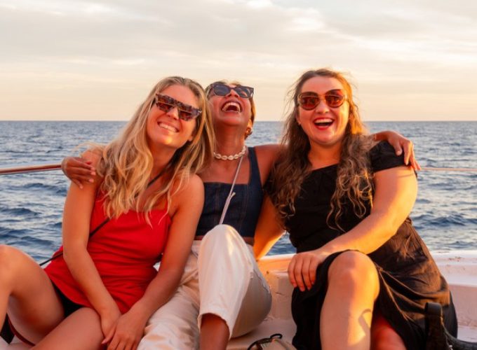 Groupe d'amis profitant de la zone chill-out du bateau au coucher du soleil à Palma
