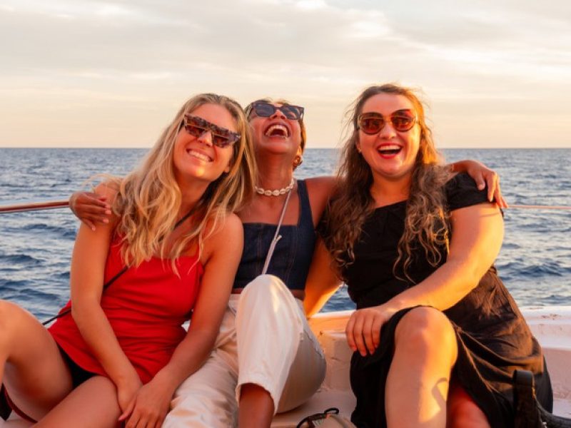 Groupe d'amis profitant de la zone chill-out du bateau au coucher du soleil à Palma